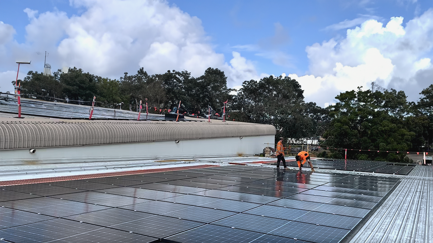 Expert team inspecting solar panel installation on the rooftop of Darrell Lea