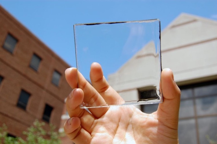 Close-up of a hand holding a transparent square glass object
