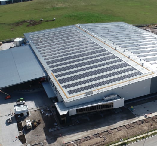 Aerial view of solar panels installed on the rooftop of an industrial warehouse